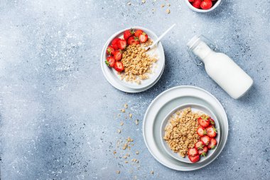 Sağlıklı kahvaltı kavramı granola, çilek ve sütle. Metin için kopyalama alanı olan en üst görüntü.