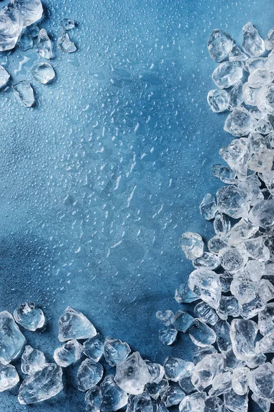 Different crystals of ice on the blue background, selective focus image with a copy space