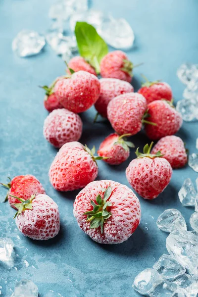 파란색 배경에 결정이 얼어붙은 딸기는 선택적으로 초점을 맞추는 이미지를 가지고 — 스톡 사진