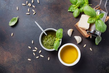 Geleneksel taze İtalyan pesto fesleğen, çam fıstığı, peynir ve yağlı siyah arka plan. Fotokopi alanı olan en üst görüntü