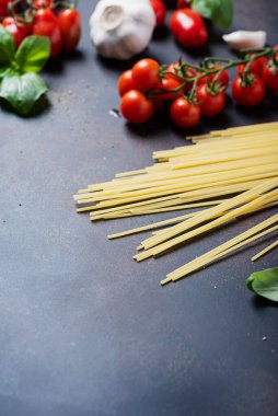İtalyan makarnası pişirmek için gerekenler: spagetti, domates, fesleğen ve sarımsak. Kopyalama alanı olan seçici odak resmi