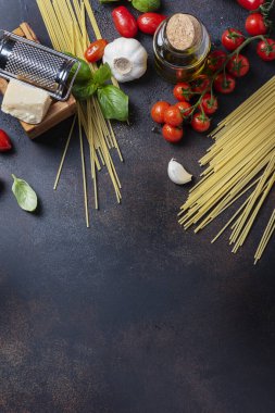 İtalyan yemeği kavramı: spagetti, domates, fesleğen, sarımsak, peynir ve siyah masadaki zeytinyağı. Kopyalama alanı olan üst görünüm