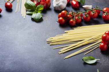 İtalyan makarnası pişirmek için gerekenler: spagetti, domates, fesleğen ve sarımsak. Kopyalama alanı olan seçici odak resmi