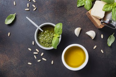 Geleneksel taze İtalyan pesto fesleğen, çam fıstığı, peynir ve yağlı siyah arka plan. Fotokopi alanı olan en üst görüntü