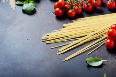 İtalyan makarnası pişirmek için gerekenler: spagetti, domates, fesleğen ve sarımsak. Kopyalama alanı olan seçici odak resmi