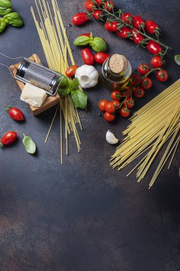 İtalyan yemeği kavramı: spagetti, domates, fesleğen, sarımsak, peynir ve siyah masadaki zeytinyağı. Kopyalama alanı olan üst görünüm