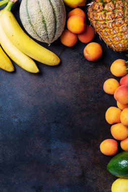 Sağlıklı vejetaryen yemeği kavramı. Ananas, muz, kayısı, kavun, siyah arka planda avokado. En üst görüntü