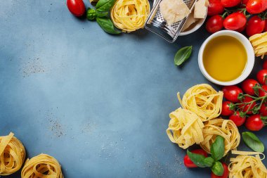 Çiğ tagliatelle, domates, fesleğen, zeytinyağı, tuz ve biberli İtalyan yemeği kavramı. Kopyalama alanı olan en üst görüntü