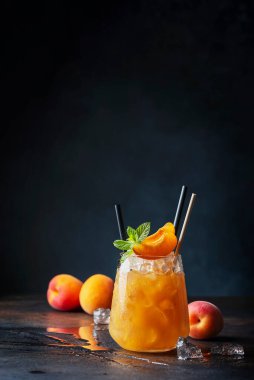 Bar konsepti ve yaz içkileri konsepti. Kayısı, buz ve nane arkaplanda bir bardak yaz kokteyli. Seçici odak resmi.