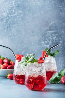 Bar konsepti. Buzlu kırmızı kokteyl ve mavi arka planda taze çilek. Metnin için bir kopya alanı olan seçici odak resmi