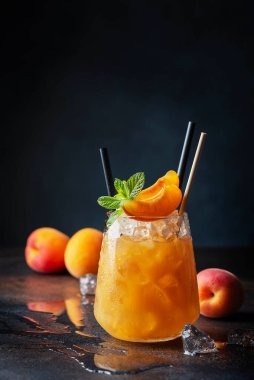 Bar konsepti ve yaz içkileri konsepti. Kayısı, buz ve nane arkaplanda bir bardak yaz kokteyli. Seçici odak resmi.