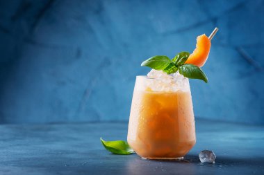 Bar konsepti. Tatlı yaz likörü, kavun, buz ve fesleğen, mavi arka planda. Metnin için kopyalama alanı olan seçici odak resmi
