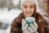 mladá žena s hrnek na teplé zimní portrét.