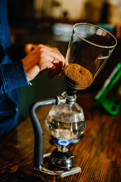 brewing coffee siphon. step by step cooking instructions. coffee is ready. Barista pouring brewed coffee in the cup