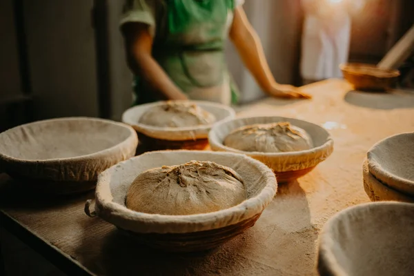 Female baker kneading dough in a bakery