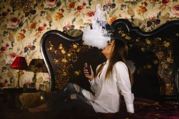 Γυναίκα Καπνίζει Ένα Ηλεκτρονικό Τσιγάρο Ξαπλωμένη Στο Κρεβάτι Ένα Δωμάτιο — Φωτογραφία Αρχείου