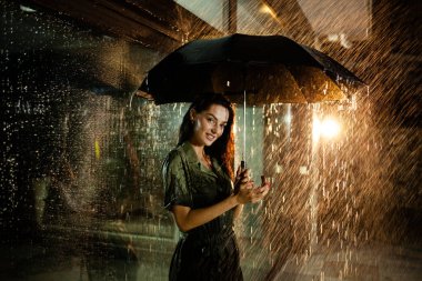 Kadın yağmurun altında duruyor.