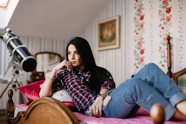 Teleskop arka planında genç, rüya gibi bir esmerin portresi.