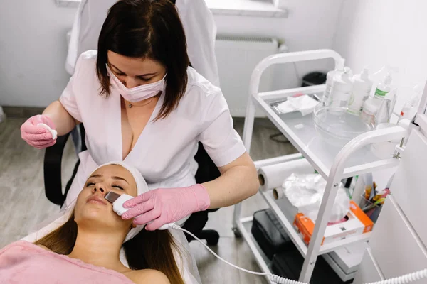 Woman getting laser and ultrasound face treatment in medical spa center