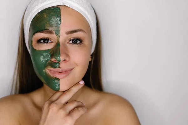 Woman with green peel-off mask on her face isolated on white background