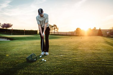 Golf oynayan genç adam.