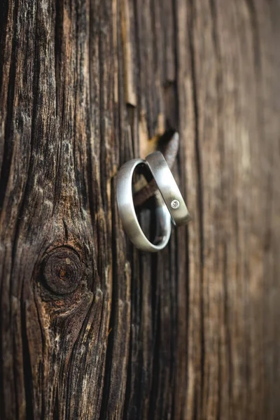 固定在木板上的旧钉子上的结婚戒指 — 图库照片