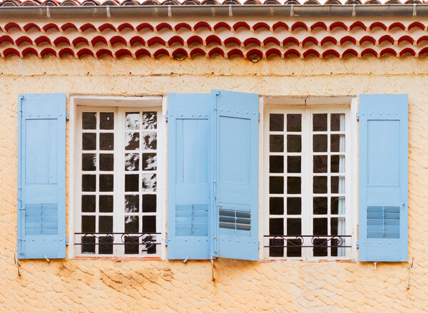 Windows with blue shutters, beautiful details of provencal typical small old town in Provence, France