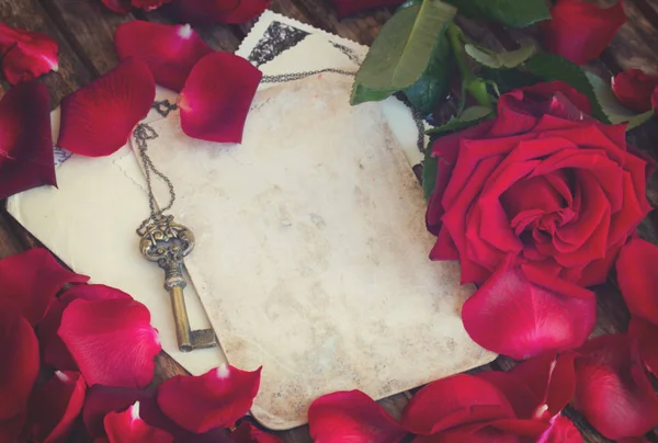 Винтажный фон с лепестками роз и ключом — стоковое фото