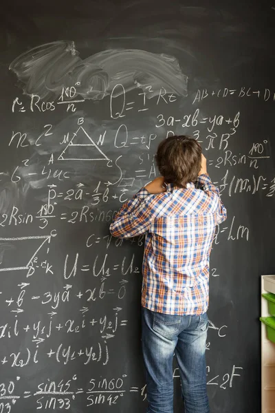 Boy writting on black board — Stok Foto