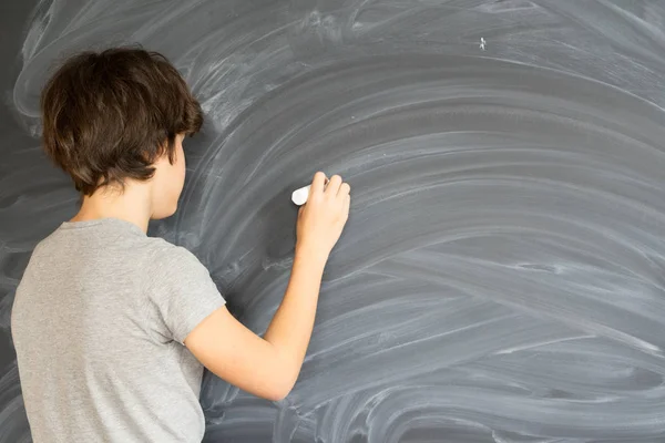 Boy writting on black board — Stok Foto