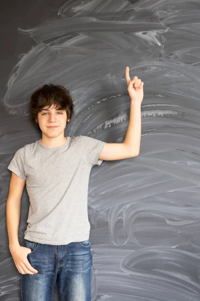 Chłopiec pisze na czarnej tablicy — Zdjęcie stockowe