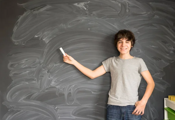 Boy writting on black board — Stock Photo, Image