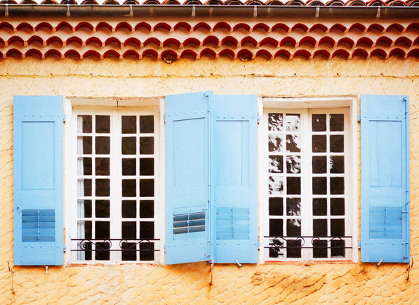 Windows with blue shutters, beautiful details of provencal typical small old town in Provence, France, retro toned