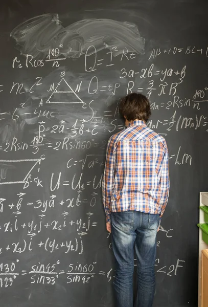 Boy writting on black board — Stock Photo, Image