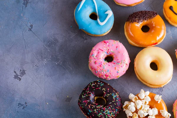 Sweet doughnuts on gray stone background — Stock Photo, Image