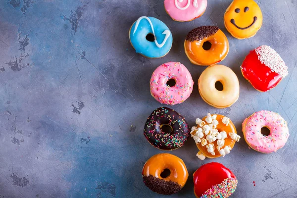 Zoete donuts op grijze stenen achtergrond — Stockfoto