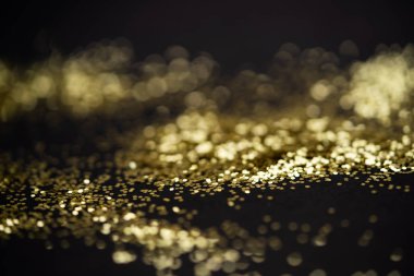 Güzel bir Noel ışığı arka planı. Soyut parıltı bokeh ve saçılmış altın parıltıları, siyah üzerine