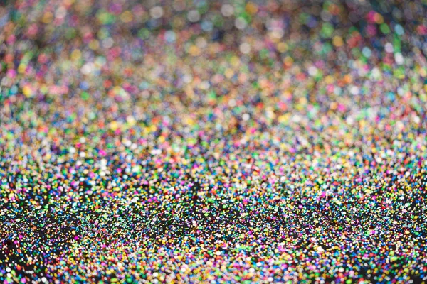 Mooie kerst lichte achtergrond. Abstract glitter bokeh en verspreide glitters in goud, op zwart — Stockfoto