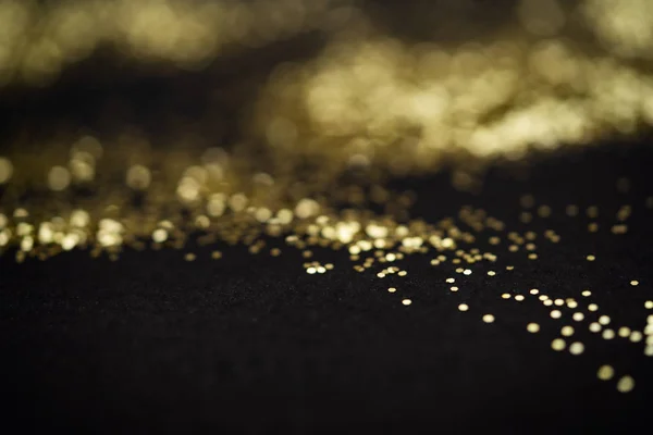 Piękne tło Christmas light. Streszczenie brokat bokeh i rozproszone musujące w złocie, na czarno — Zdjęcie stockowe