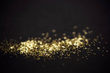 Güzel bir Noel ışığı arka planı. Soyut parıltı bokeh ve saçılmış altın parıltıları, siyah üzerine