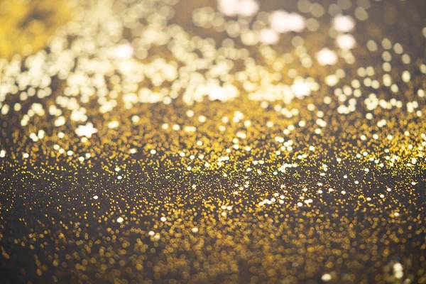 Bela luz de Natal fundo. Abstrato glitter bokeh e brilhos espalhados em ouro, em preto — Fotografia de Stock