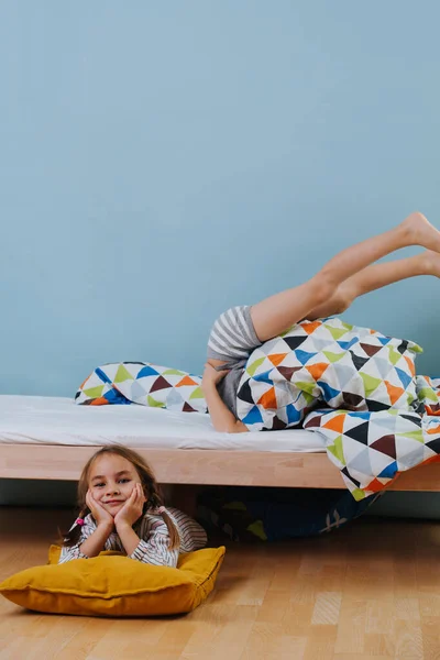 Küçük çocuk ve kız mavi duvarlarla yatak odasında oynuyorlar. Herkes işini yapıyor.. — Stok fotoğraf