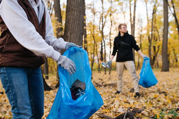 Primer plano de un grupo de voluntarios recogiendo basura en el bosque estacional en otoño — Foto de Stock