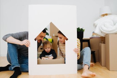 Çerçeveye benzeyen bir evde oynayan küçük bir çocuk.