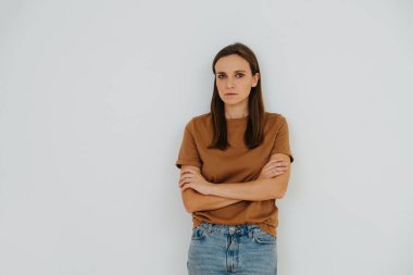 Bir kadın portresi, elleri çapraz ve ciddi, stresli görünüm.