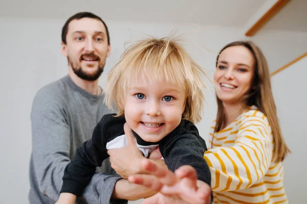 Parents palying with their son, holding him in the air and moving around. — Stock Photo, Image