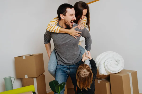 Familia celebrando mudarse a un nuevo apartamento. Se están divirtiendo juntos. . — Foto de Stock