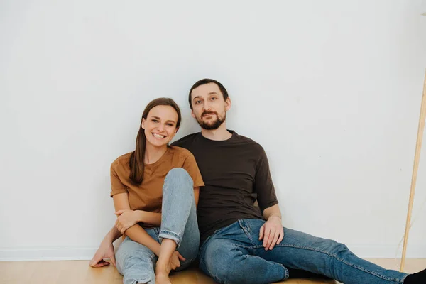 Retrato de una pareja de mediana edad sentada en el piso del nuevo apartamento —  Fotos de Stock
