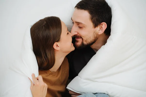 Primer plano retrato de una pareja de mediana edad sentada envuelta en una manta, besándose — Foto de Stock