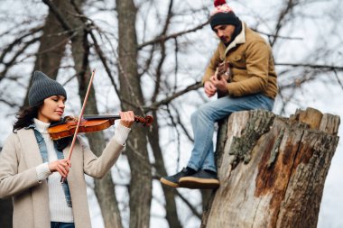 Müzikal düet güzel yapraksız sonbahar ormanında müzik çalıyor.